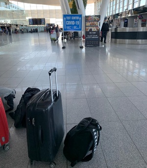 zdjęcie ilustracyjne bagaży na terminalu lotniska stoi czarna walizka i kilka innych bagaży obok niej