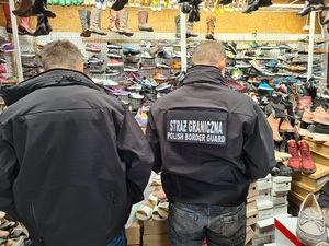 Funkcjonariusze Straży Granicznej podczas kontroli stoiska z podrobiona odzieżą Funkcjonariusze Straży Granicznej podczas kontroli stoiska z podrobiona odzieżą