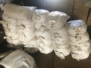 Zatrzymany tytoń Białe worki z tytoniem leżą na podłodze w murowanym garażu