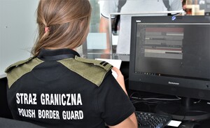 Funkcjonariusz Nadodrzańskiego Oddziału Straży Granicznej podczas odprawy paszportowej na lotnisku Funkcjonariusz Nadodrzańskiego Oddziału Straży Granicznej podczas odprawy paszportowej na lotnisku